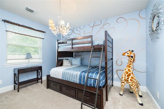 This generous secondary bedroom offers endless possibilities—whether for a guest room, home office, or playroom, the soft, patterned carpeting and cohesive design make it a comfortable, welcoming space to unwind or get creative. | Image 19
