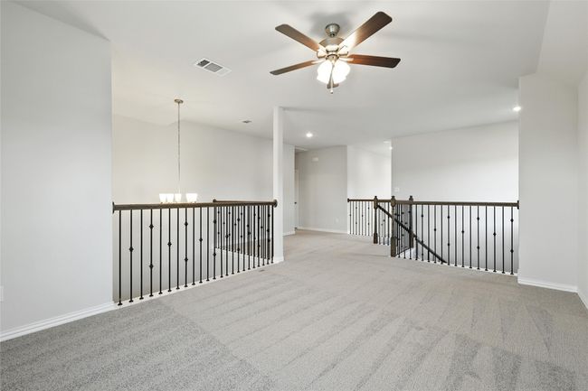 Carpeted spare room featuring ceiling fan, recessed lighting, and a chandelier | Image 22