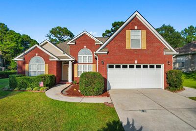 View of property featuring a garage and a front lawn | Image 1