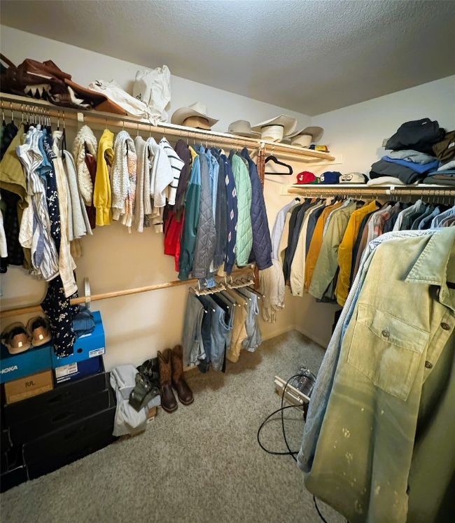 Spacious primary closet with carpet floors | Image 29