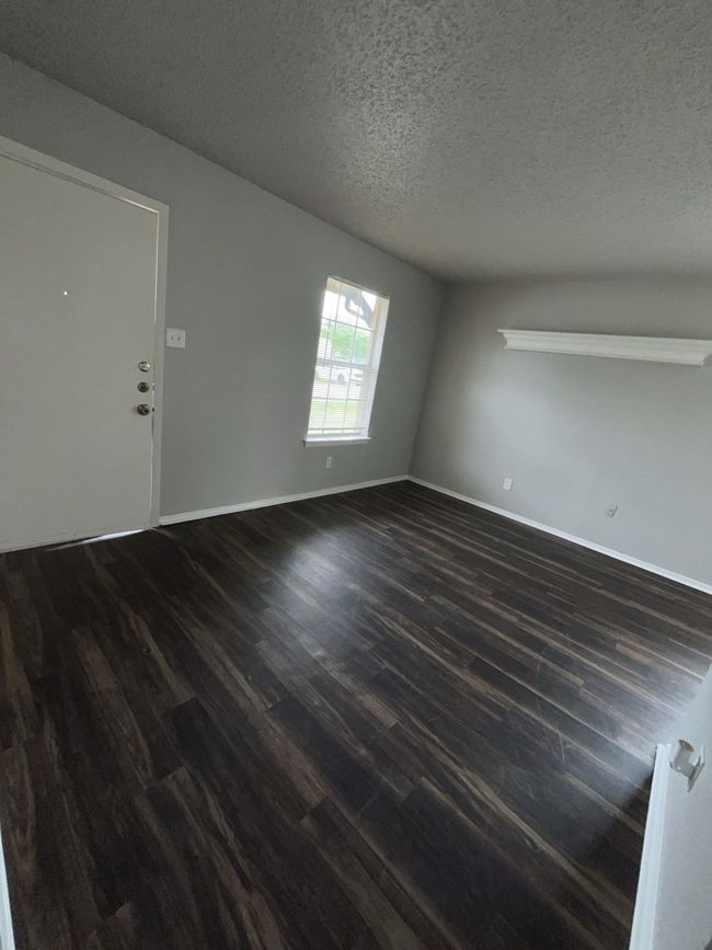 Spare room with dark wood finished floors, a textured ceiling, and baseboards | Image 9