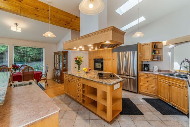 Kitchen with open shelves, black appliances, a sink, high vaulted ceiling, and a skylight | Image 17
