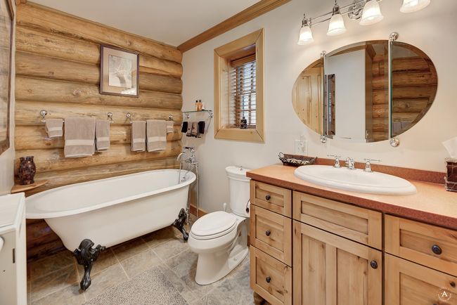 Full bathroom featuring rustic walls, a soaking tub, and vanity | Image 20