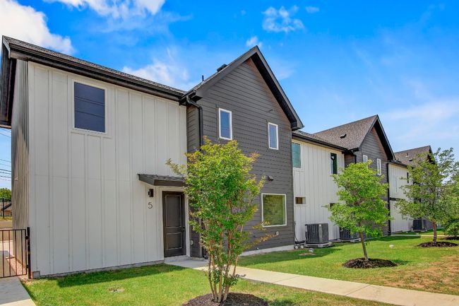 View of front of property featuring board and batten siding, central AC, and a front lawn | Image 32