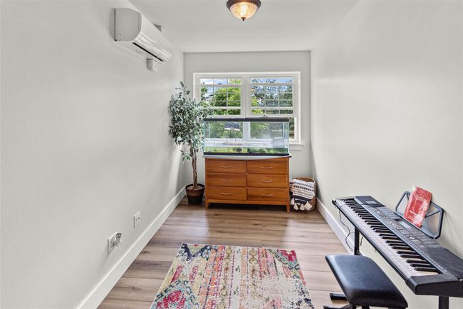 Sitting room featuring an AC wall unit and wood finished floors | Image 44