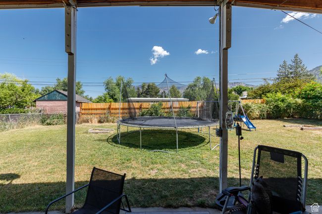 Fenced backyard featuring a trampoline and a playground | Image 30