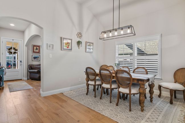 Dining room featuring baseboards, arched walkways, high vaulted ceiling, and light wood finished floors | Image 4