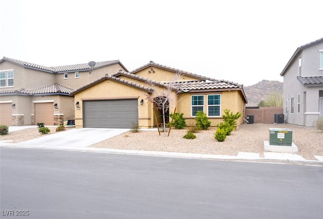Mediterranean / spanish home with driveway, a mountain view, cooling unit, a garage, and stucco siding | Image 4