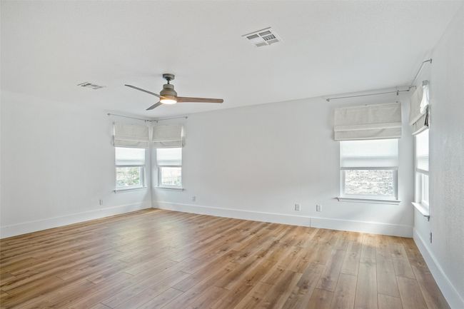Primary bedroom feature wall with fireplace. Windows on 3 walls - lots of natural light! | Image 13