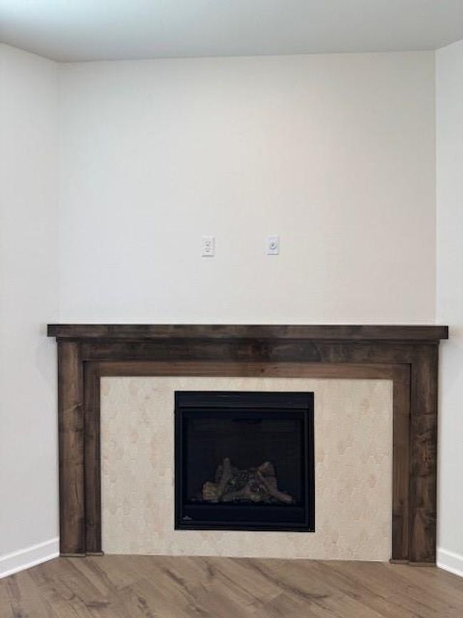 Interior details with baseboards, wood finished floors, and a tiled fireplace | Image 5