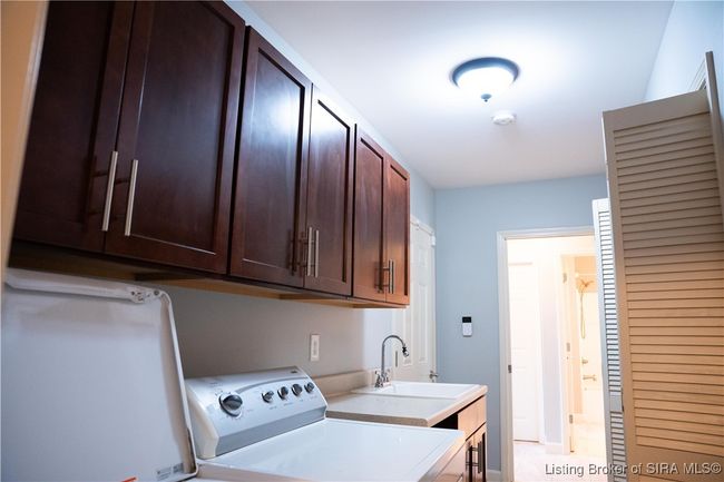 Laundry room has custom cabinetry and a laundry sink | Image 40