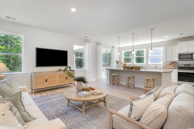 Living room with light wood finished floors, visible vents, and a wealth of natural light | Image 11