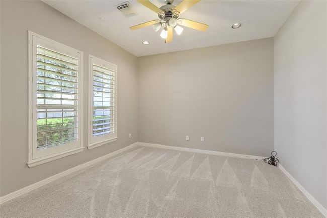 Study with double doors, ceiling fan, can lights and Plantation shutters. Carpet was installed 03/25. | Image 9