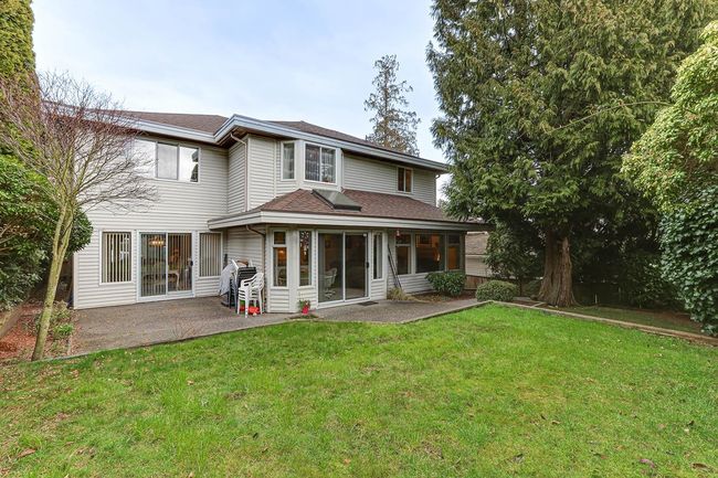 Rear view of property with a patio, a yard, and roof with shingles | Image 39