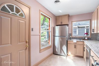 Kitchen with light stone counters, sink, stainless steel appliances, backsplash, and light brown cabinets | Image 3