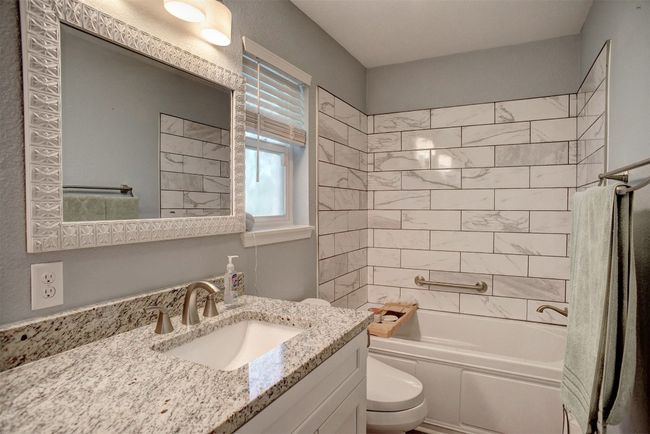 Bathroom featuring vanity and tub / shower combination | Image 19