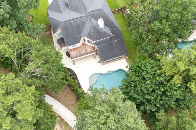 Aerial top view captures your own private retreat with a sparkling pool and expansive patio. To the left, a golf cart path grants you an extra buffer between you and your neighbor. | Image 43
