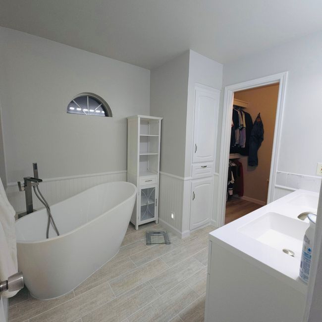 Full bathroom with vanity, a freestanding bath, a spacious closet, and a wainscoted wall | Image 17
