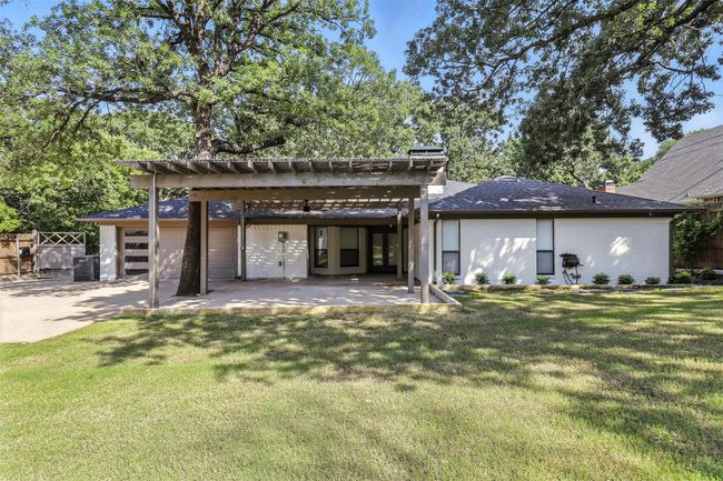 Rear view of house featuring a pergola, a patio, and concrete driveway | Image 36