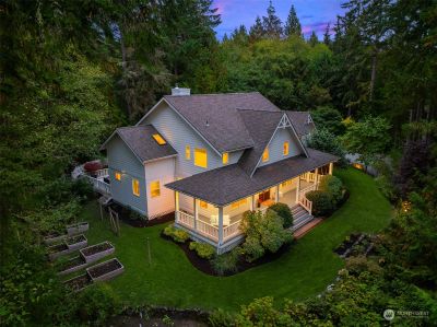 Nestled on a private lot with mature gardens, generous wraparound porch & decks, this home offers tranquility amidst the natural beauty of the PNW. | Image 2