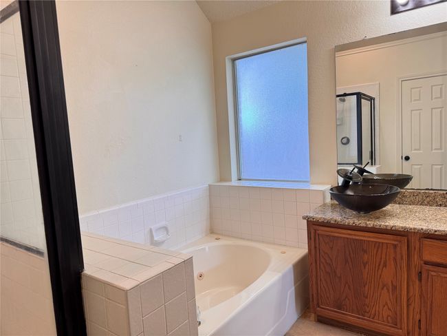 Full bath featuring a shower stall, a garden tub, and vanity | Image 9