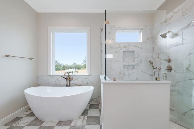 Bathroom with a marble finish shower, a soaking tub, and marble finish flooring | Image 29