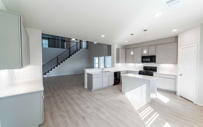 Kitchen with black appliances, tasteful backsplash, light wood finished floors, light countertops, and recessed lighting | Image 8