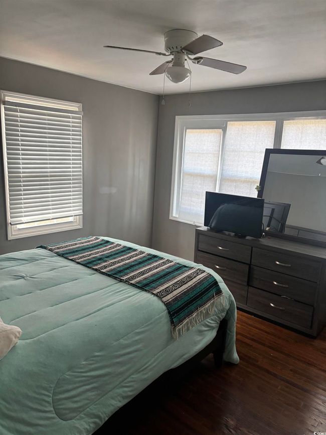 Bedroom with dark wood-type flooring, multiple windows, and a ceiling fan | Image 20