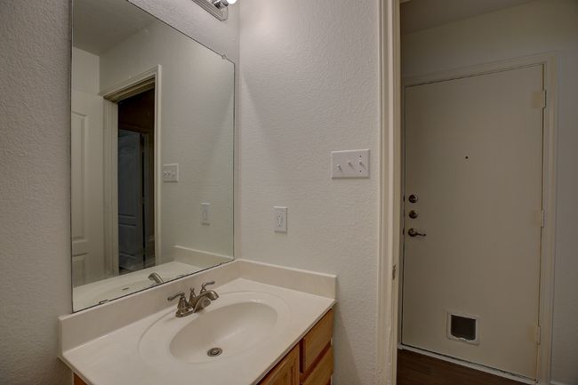 Bathroom featuring vanity, a textured wall, and wood finished floors | Image 33