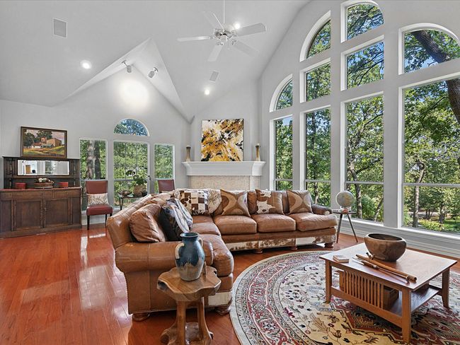 Living area with plenty of natural light, hardwood / wood-style floors, and high vaulted ceiling. Floor to ceiling windows facing north. | Image 6