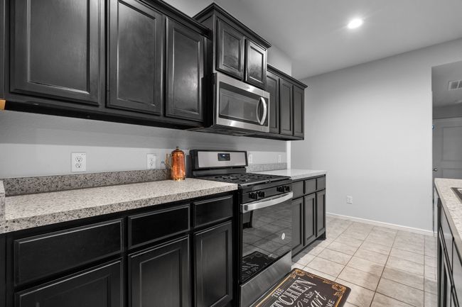 Kitchen featuring light countertops, dark cabinetry, and appliances with stainless steel finishes | Image 10
