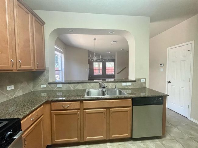 Kitchen with appliances with stainless steel finishes, a sink, arched walkways, and decorative backsplash | Image 6