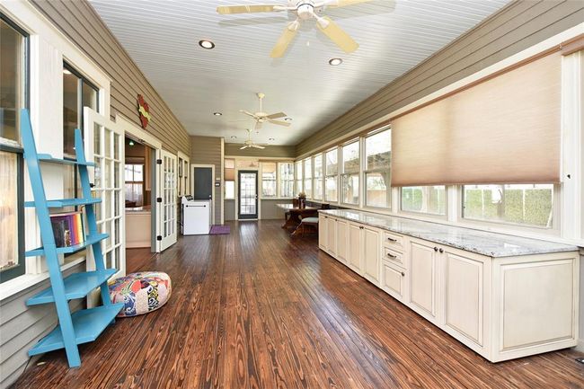 This sunroom is massive. The cabinet that is granite topped is perfect for all kinds of projects with storage galore. All thie blinds are automated. This property is very private as there is a fence all around that is gated. | Image 14