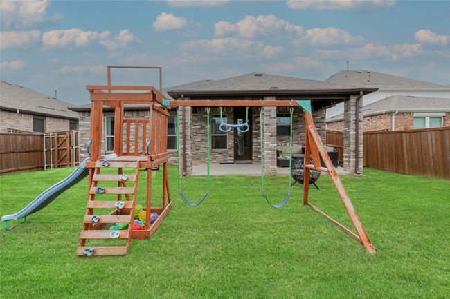 View of jungle gym with a yard, a patio, and a fenced backyard | Image 15