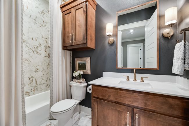 Full bathroom featuring marble look tiles, toilet, baseboards, vanity, and shower / tub combo with curtain | Image 21
