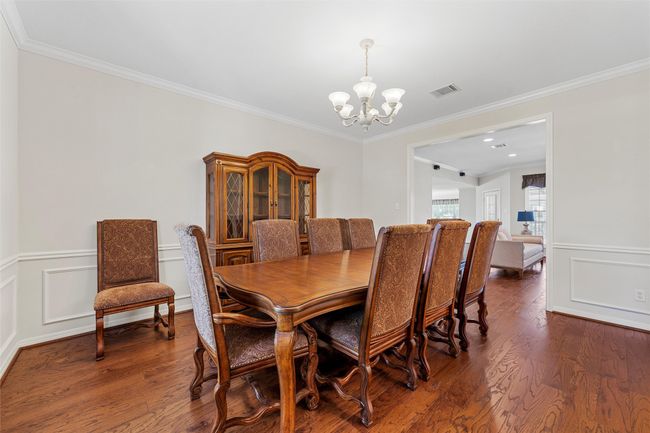 Dining room featuring ornamental molding, a notable chandelier, and wood finished floors | Image 5