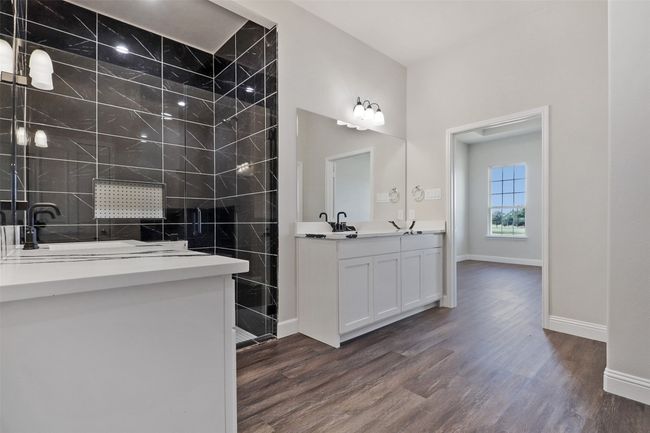 Full bath with walk in shower, vanity, wood finished floors, and baseboards | Image 10