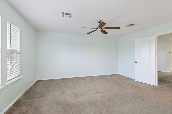 Carpeted bedroom featuring healthy amount of natural light, a ceiling fan, and baseboards | Image 28