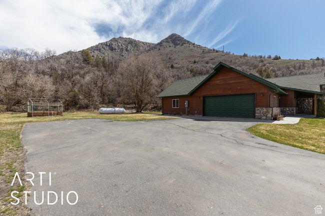 Exterior space featuring a mountain view, driveway, a garage, and a front lawn | Image 52