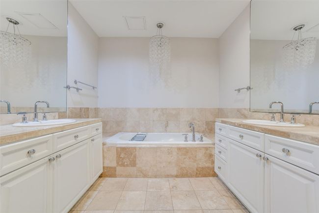 Bathroom featuring tiled bath, two vanities, and a sink | Image 11