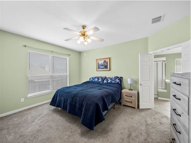 Bedroom featuring baseboards, ceiling fan, visible vents, and light colored carpet | Image 16