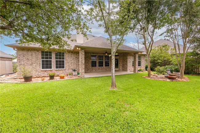 Rear view of house featuring a patio, brick siding, a lawn, and ceiling fan | Image 36