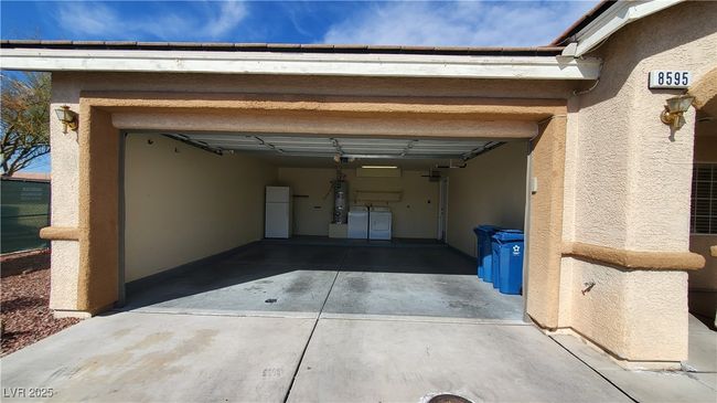 Garage featuring a garage door opener, driveway, washing machine and clothes dryer, and freestanding refrigerator | Image 26