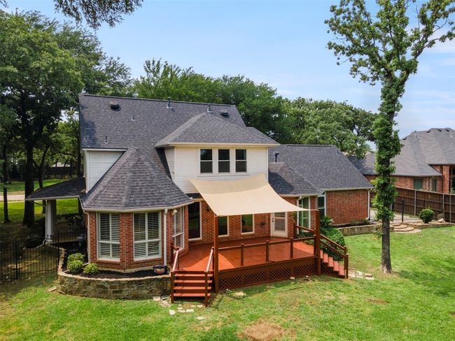 Rear view of property with brick siding, a deck, and a shingled roof | Image 11