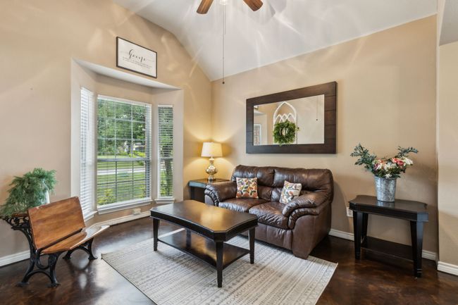 Living area with vaulted ceiling, ceiling fan, and concrete flooring | Image 4