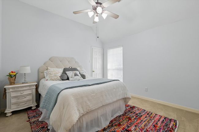 Bedroom with carpet flooring, baseboards, vaulted ceiling, and a ceiling fan | Image 28