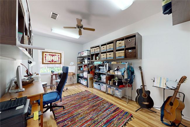 Office area with a ceiling fan, wood finished floors, and visible vents | Image 23