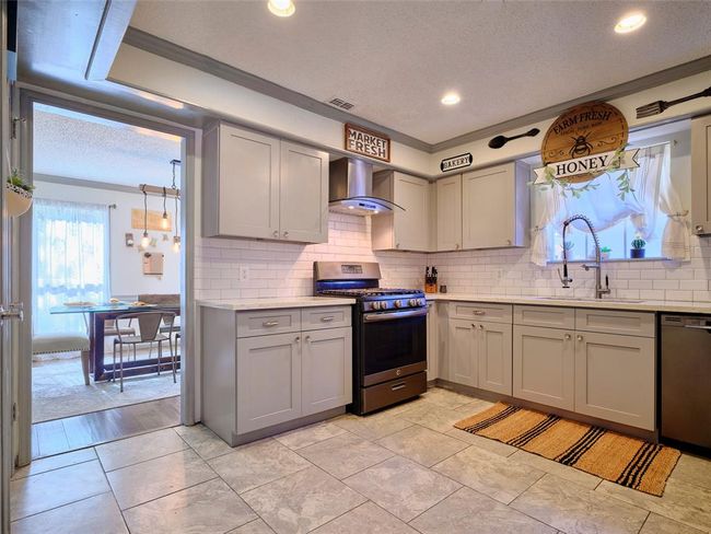 The kitchen is ideally situated, allowing for easy access to the dining area, den, and entryway. | Image 12