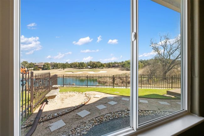 View of the back yard and pond from the primary bedroom window. | Image 18