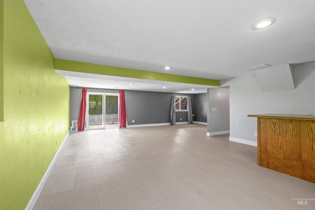 Unfurnished living room featuring a bar, wood finished floors, and recessed lighting | Image 37